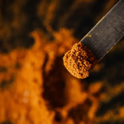 Cúrcuma en polvo sobre cuchara, rica en curcumina antiinflamatoria